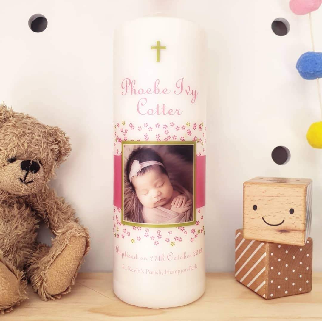 Baby photo and flowers on a Baptism candle with a teddy bear and 2 wooden toy blocks