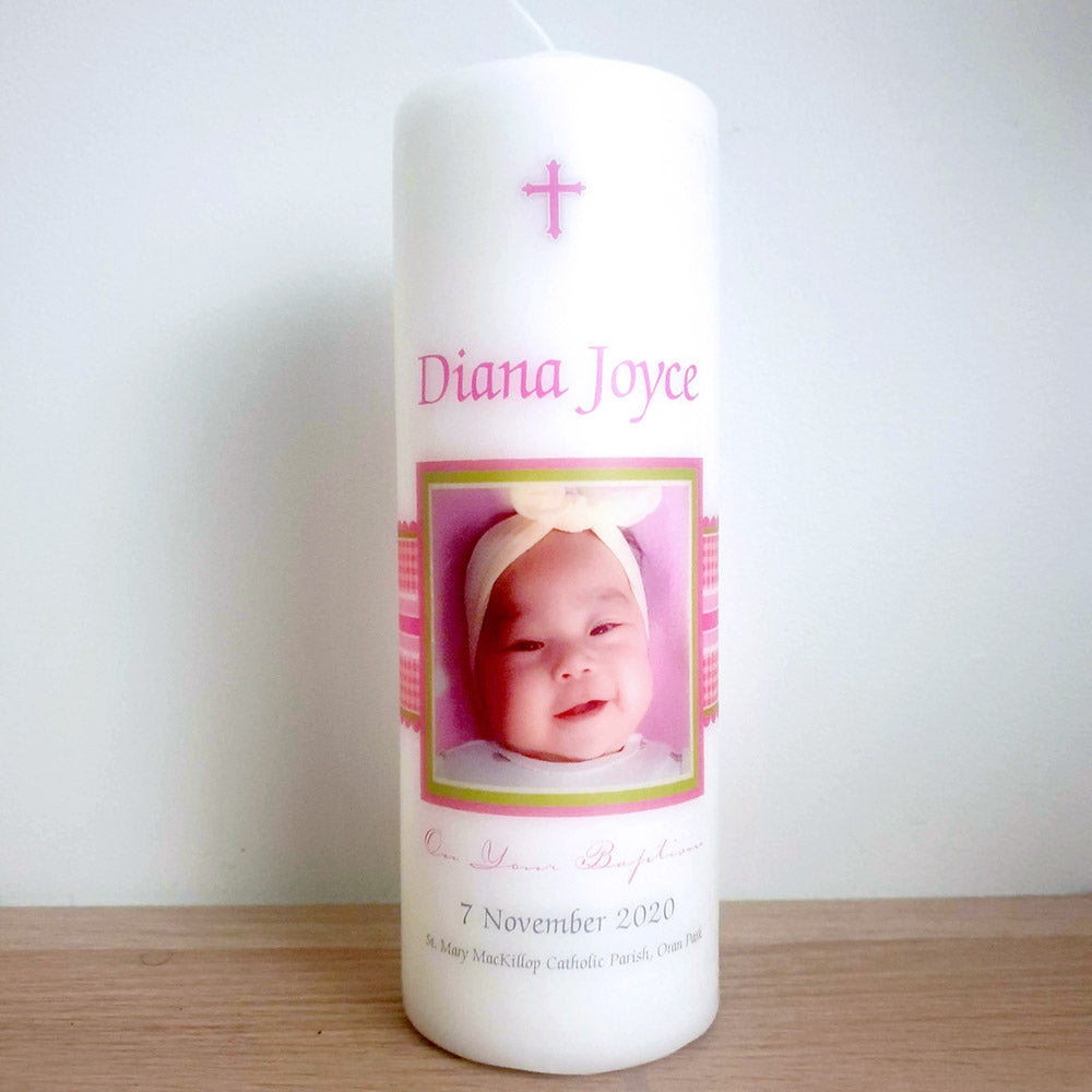 White pillar Baptism candle with photo of a baby, pink writing and checked ribbon